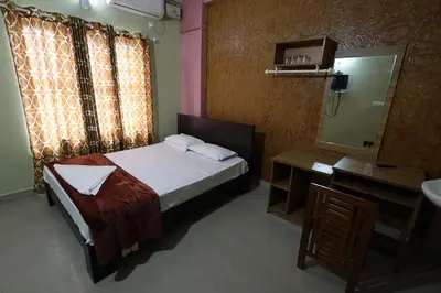 a bedroom with a bed and a sink and a mirror at Wayanad regal residency in Kalpetta