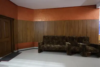 a waiting room with a couch and wooden walls at Wayanad regal residency in Kalpetta