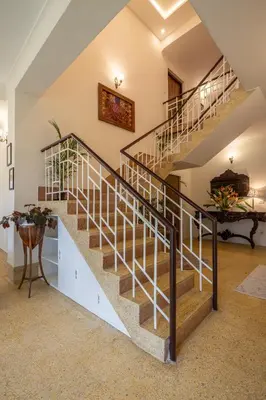 a winding staircase in a home with white walls at ama Stays & Trails Skanda , Coorg in Madikeri
