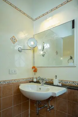 a bathroom with a white sink and a mirror at ama Stays & Trails Skanda , Coorg in Madikeri