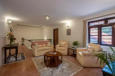 a living room with couches and a table at ama Stays & Trails Skanda , Coorg in Madikeri