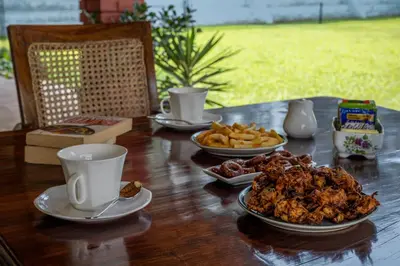 a table with plates of food and cups on it at ama Stays & Trails Skanda , Coorg in Madikeri