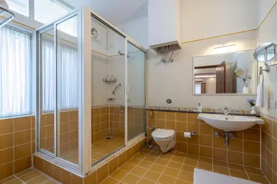 a bathroom with a shower and a toilet and a sink at ama Stays & Trails Skanda , Coorg in Madikeri