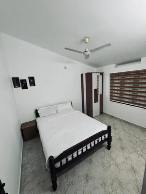 a bed in a white room with a ceiling at Chills homestay in Kalpetta