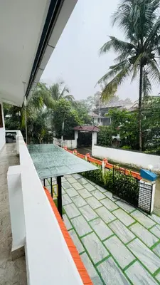 a table on a balcony with a view of a courtyard at Chills homestay in Kalpetta