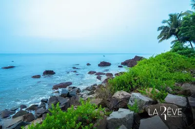 a view of the ocean from a rocky beach at LA RÊVE The Beach Villa in Malappuram