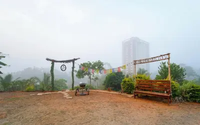 a park with a bench and a grill and flags at Vythiri Palace Wayanad Pool Resort - Mist Climate & India's First Apple Infinity Pool in Vythiri