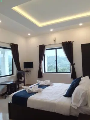 a bedroom with a large bed with windows and a desk at Vythiri Palace Wayanad Pool Resort - Mist Climate & India's First Apple Infinity Pool in Vythiri