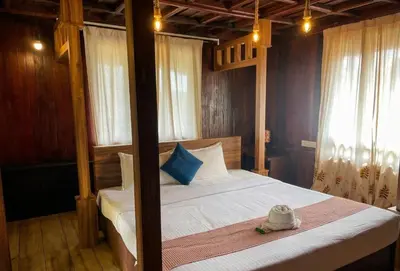 a bedroom with a canopy bed with a hat on it at Vythiri Palace Wayanad Pool Resort - Mist Climate & India's First Apple Infinity Pool in Vythiri