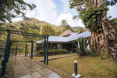 a building with a gate and a tree at Elixir Woods Luxury Resort And Spa, Munnar in Munnar