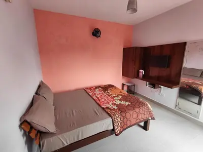 a bedroom with a bed and a tv on the wall at Ooty Prakash Residency in Ooty