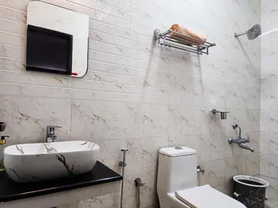 a bathroom with a sink and a toilet and a tv at Cloud & Mist Inn-Whole Villa Stay with Mountain Views in Kotagiri, Near Ooty in Kotagiri