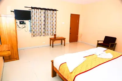 a bedroom with a bed and a tv in a room at J J HOMES in Ooty
