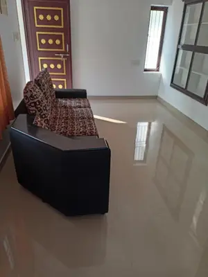 a black chair sitting in a room with a floor at Space villa Homestay in Irimbranallūr