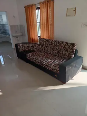 a couch sitting in a living room in a room at Space villa Homestay in Irimbranallūr