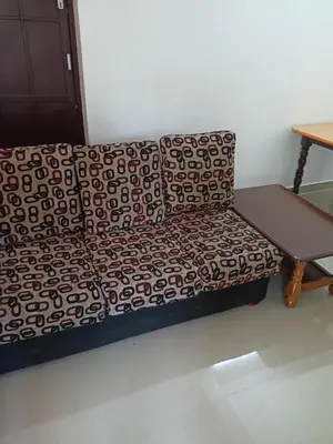 a couch sitting in a room with a table at Space villa Homestay in Irimbranallūr