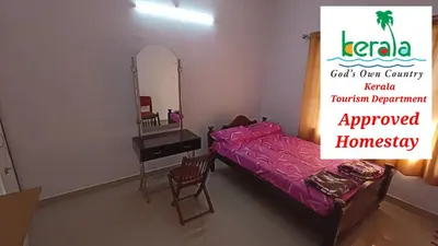 a room with a bed and a desk and a mirror at Space villa Homestay in Irimbranallūr
