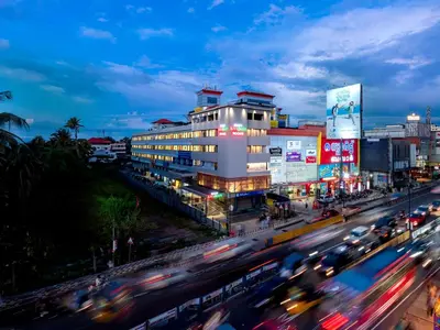 a busy city street with traffic in front of a building at Hotel Stay Bella Kozhikode in Kozhikode