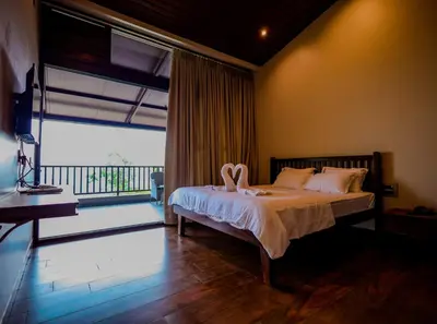 a bedroom with a bed and a large window at The Odyssey Coorg in Madikeri