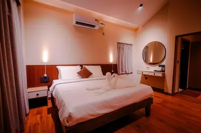 a bedroom with a bed with a towel animal on it at The Odyssey Coorg in Madikeri