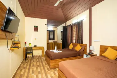 a hotel room with two beds and a television at Hill Valley Farm House in Nelliyampathy