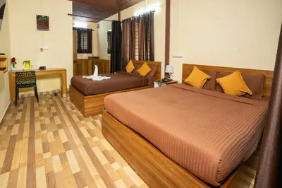 a hotel room with two beds and a desk and a desk at Hill Valley Farm House in Nelliyampathy