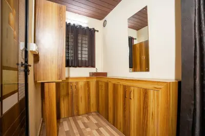 a bathroom with wooden cabinets and a mirror at Hill Valley Farm House in Nelliyampathy