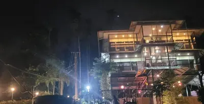 a building at night with lights in front of it at Greens Vista Homestay Wayanad Near Natural Stream and Pool in Panamaram