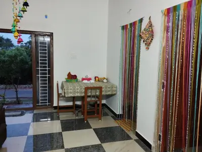 a dining room with a table and a checkered floor at SHI Triveni 1BHK at Coimbatore Outskirts in Irugūr