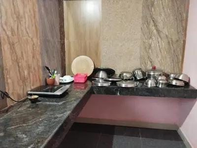 a kitchen with pots and pans on a counter at SHI Triveni 1BHK at Coimbatore Outskirts in Irugūr
