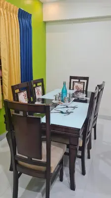 a dining room with a table and chairs at Kamalam 3BHK Villa 1AC and 2 Non AC Bedrooms in Coimbatore
