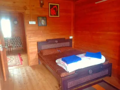 a room with a bed in a wooden room at Joy Eco Woodhouse - 3 Bhk House in Ooty