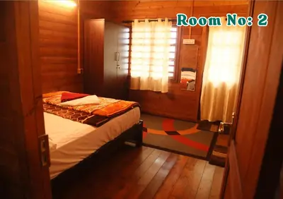 a bedroom with a bed and a window in a room at Joy Eco Woodhouse - 3 Bhk House in Ooty