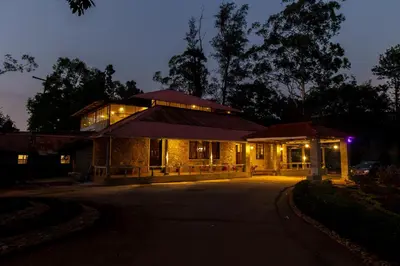 a house with lights on in the night at Harris Holiday Inn in Vālpārai