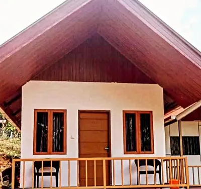 a small house with two chairs in front of it at Vattavada Jungle Resort in Munnar