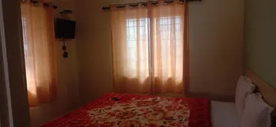 a bedroom with a bed and a window with curtains at Stay awhile in Ooty