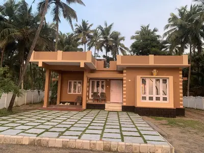 a small house in front of some palm trees at Casa Ganesha beach villa in Irimbranallūr