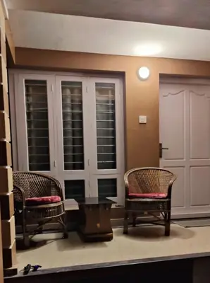 a living room with two chairs and a table at Casa Ganesha beach villa in Irimbranallūr