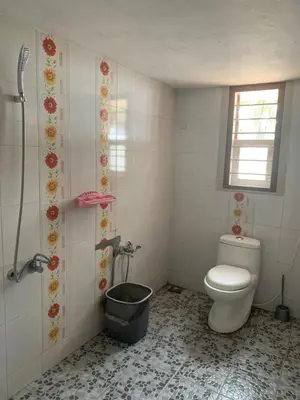 a bathroom with a toilet and a bucket at Casa Ganesha beach villa in Irimbranallūr