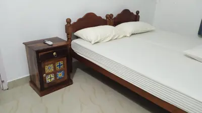 a bedroom with a bed and a nightstand next to a bed sidx sidx sidx at Casa Ganesha beach villa in Irimbranallūr