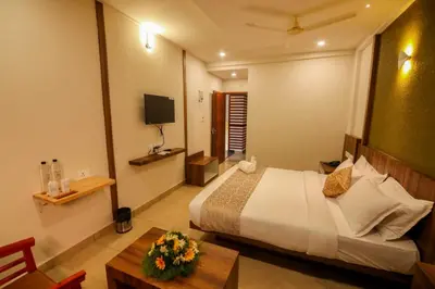 a bedroom with a bed and a table and a television at ARIAT AVENUE in Wayanad