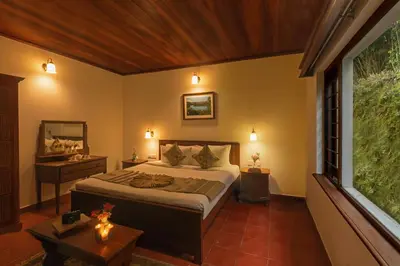 a bedroom with a bed and a large window at Emerald by Nature Resorts and Stays in Ooty