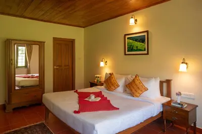 a bedroom with a bed with a red blanket on it at Emerald by Nature Resorts and Stays in Ooty
