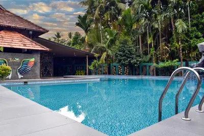 a swimming pool in front of a house at Farm Fort Resort in Kozhikode