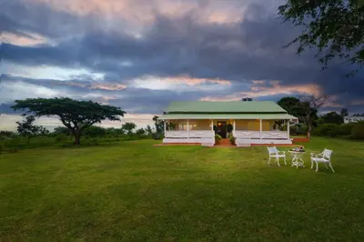 a house with two chairs and a table in a field at Wild Pastures by Nature Resorts and Stays in Masinagudi