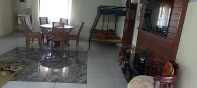 a living room with a table and chairs and a kitchen at CITADEL HOLIDAY HOME in Vythiri