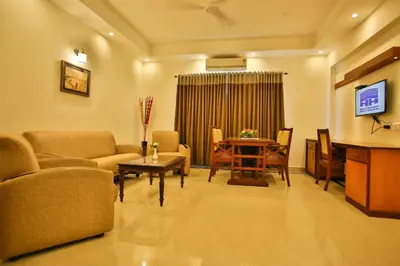 a living room with a couch and a table at Harbour Hotels in Pallipuram