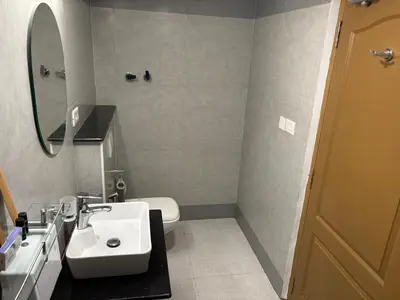 a bathroom with a white sink and a mirror at Hotel Mangala Temple View in Guruvāyūr