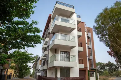 an apartment building with balconies on a street at Treebo Samanvaya Retreat, Mysore in Mysore
