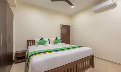 a bedroom with a large white bed with colorful pillows at Treebo Samanvaya Retreat, Mysore in Mysore